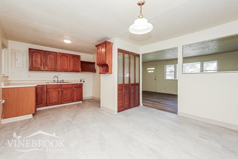 A kitchen with wooden cabinets and a white ceiling.