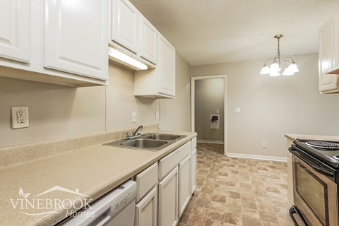 A kitchen with white cabinets and a beige countertop.