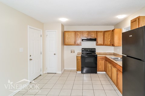 A kitchen with black appliances and wooden cabinets.