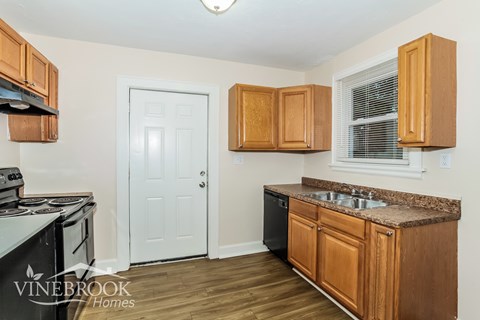 A kitchen with wooden cabinets and a black stove top oven.