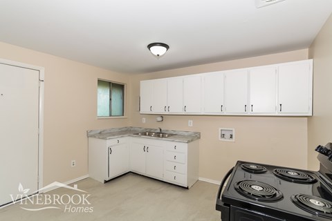 A kitchen with white cabinets and a black stove top oven.