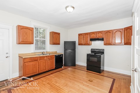 A kitchen with wooden cabinets and appliances.