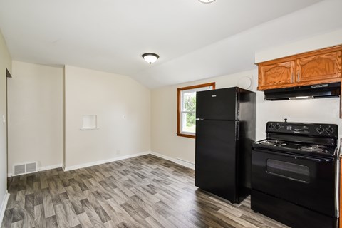 A kitchen with black appliances and wood cabinets.