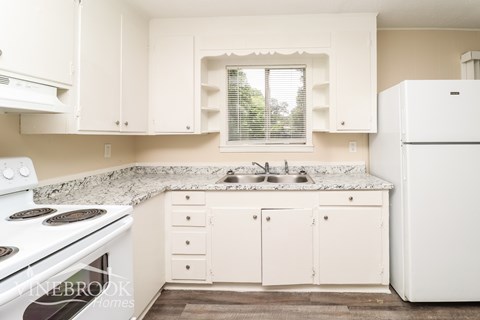 A kitchen with white appliances and cabinets.