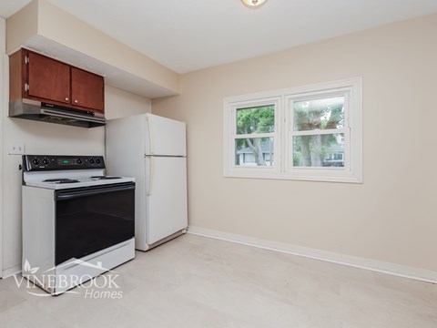 A kitchen with a stove top oven and a refrigerator.