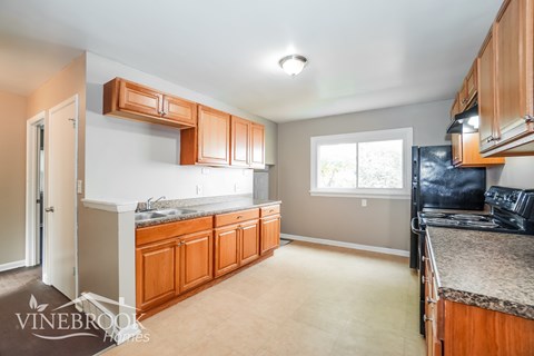 A kitchen with wooden cabinets and a granite countertop.