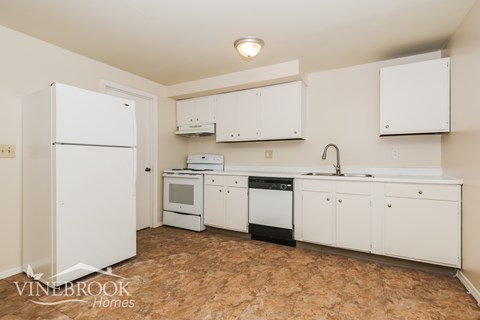 A kitchen with white appliances and cabinets.