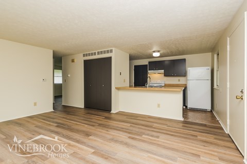 A room with a kitchenette and a refrigerator in it.