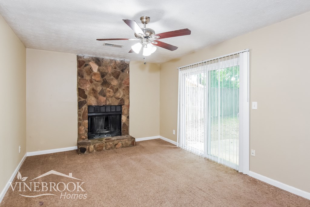 a living room with a fireplace and a ceiling fan