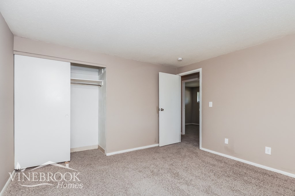 a bedroom with two closets and a carpeted floor