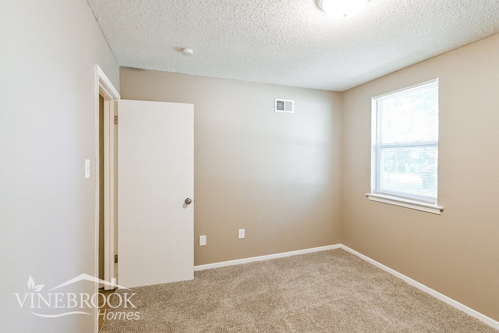a bedroom with a white door and a window