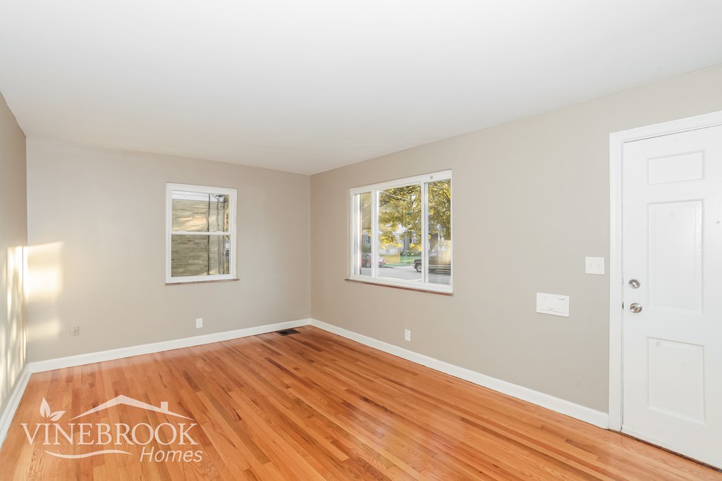 A room with a wooden floor and a white door.