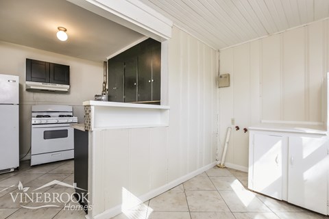 A kitchen with white cabinets and appliances.