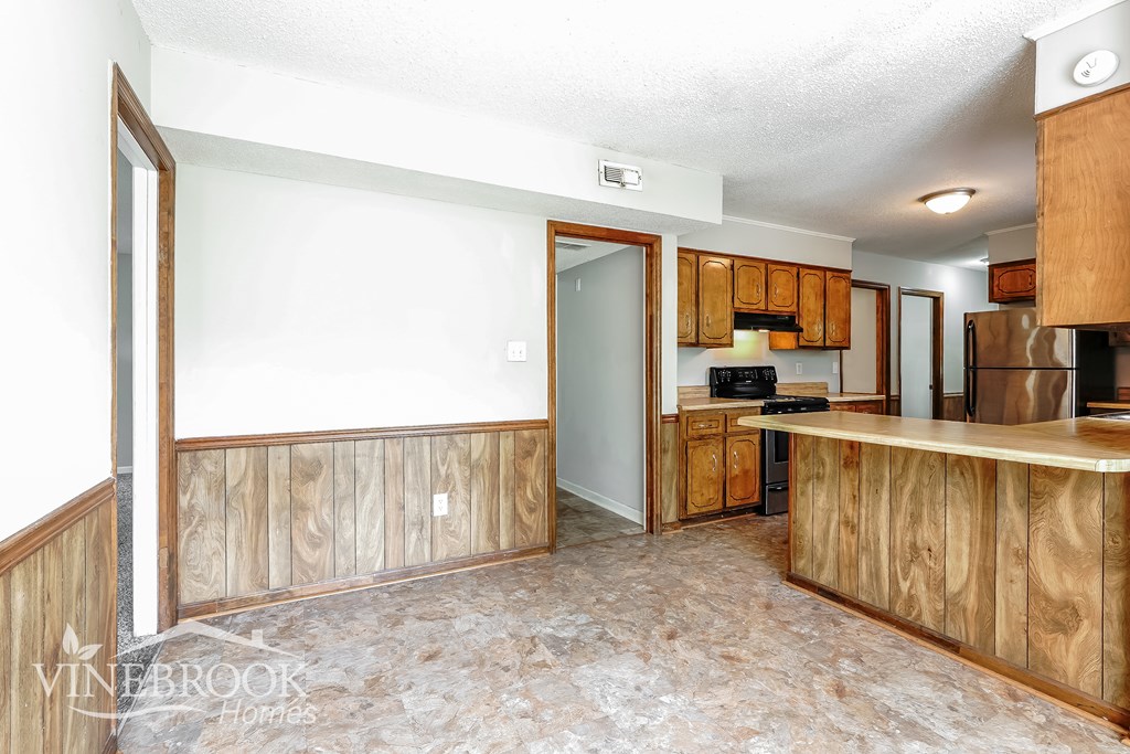 A kitchen area with wooden cabinets and a countertop.