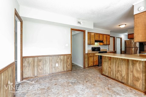 A kitchen area with wooden cabinets and a countertop.