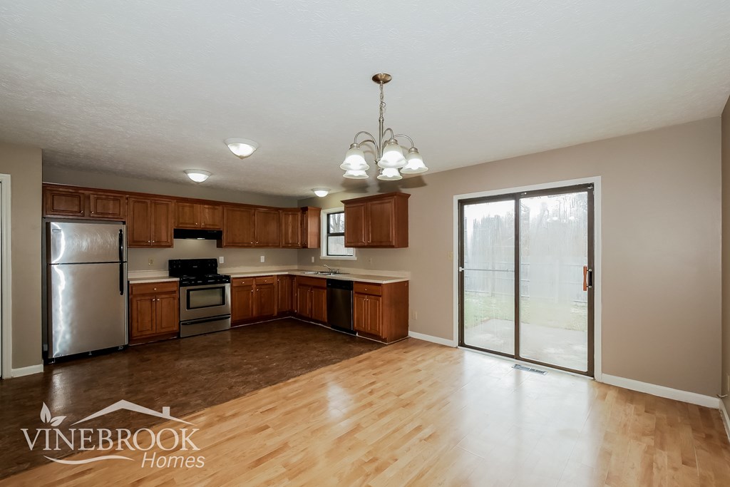 A kitchen with wooden cabinets and a refrigerator.