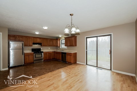 A kitchen with wooden cabinets and a refrigerator.