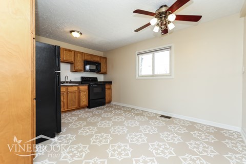 A kitchen with black appliances and wooden cabinets.