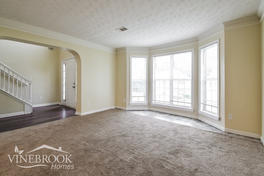 a living room with carpet and large windows