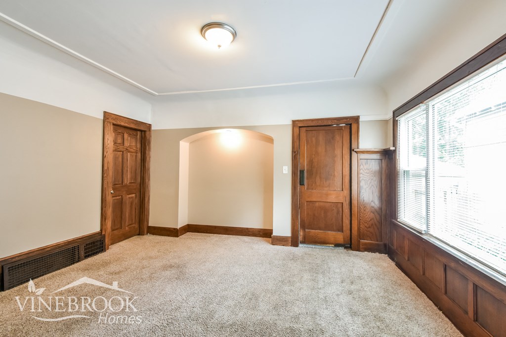 an empty living room with two doors and a window