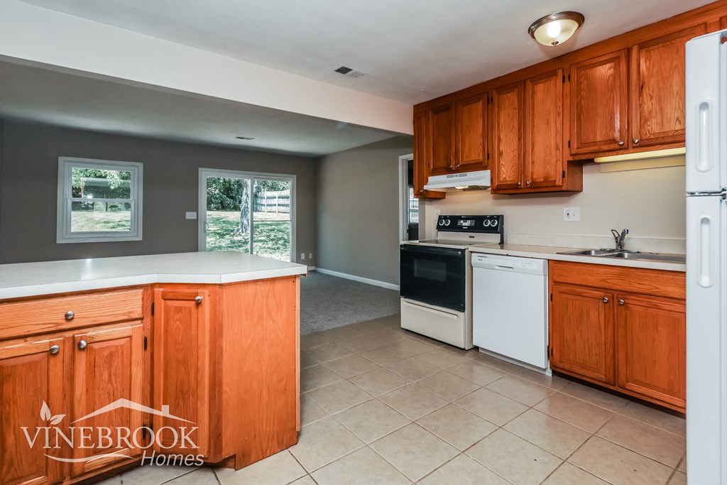 a kitchen with white appliances and wooden cabinets