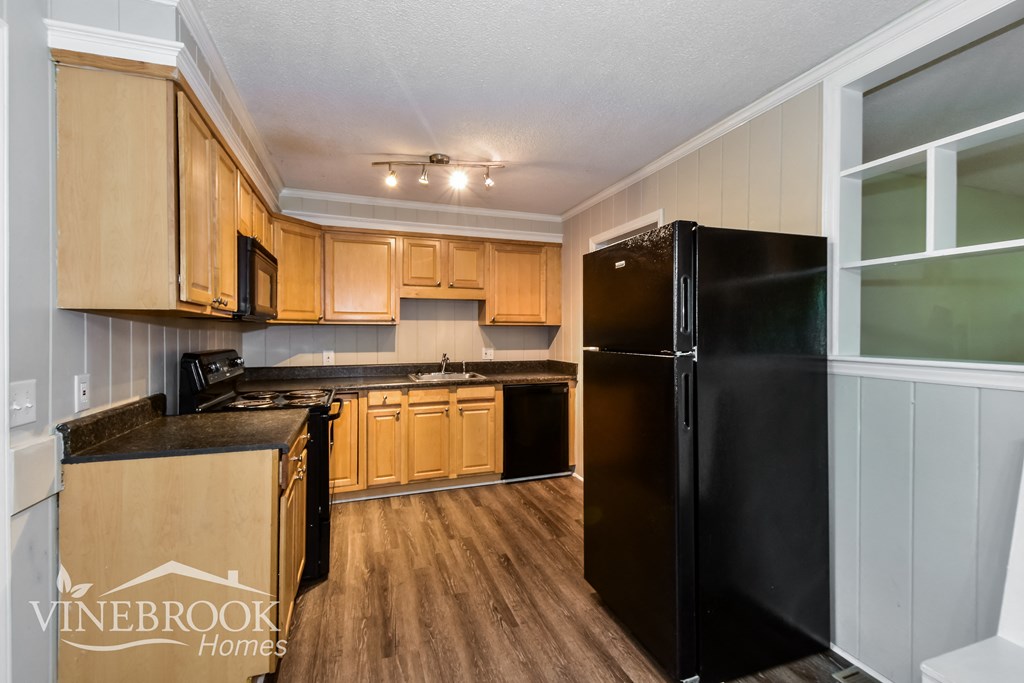 a kitchen with black appliances and wooden cabinets