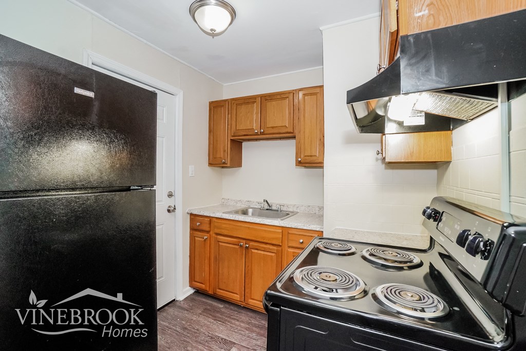 a kitchen with a stove and refrigerator and a sink