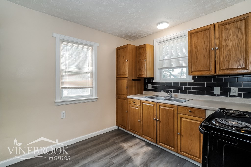 the kitchen of a home with wood cabinets and black appliances