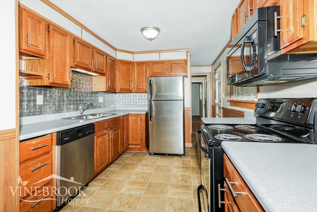 a kitchen with wooden cabinets and stainless steel appliances