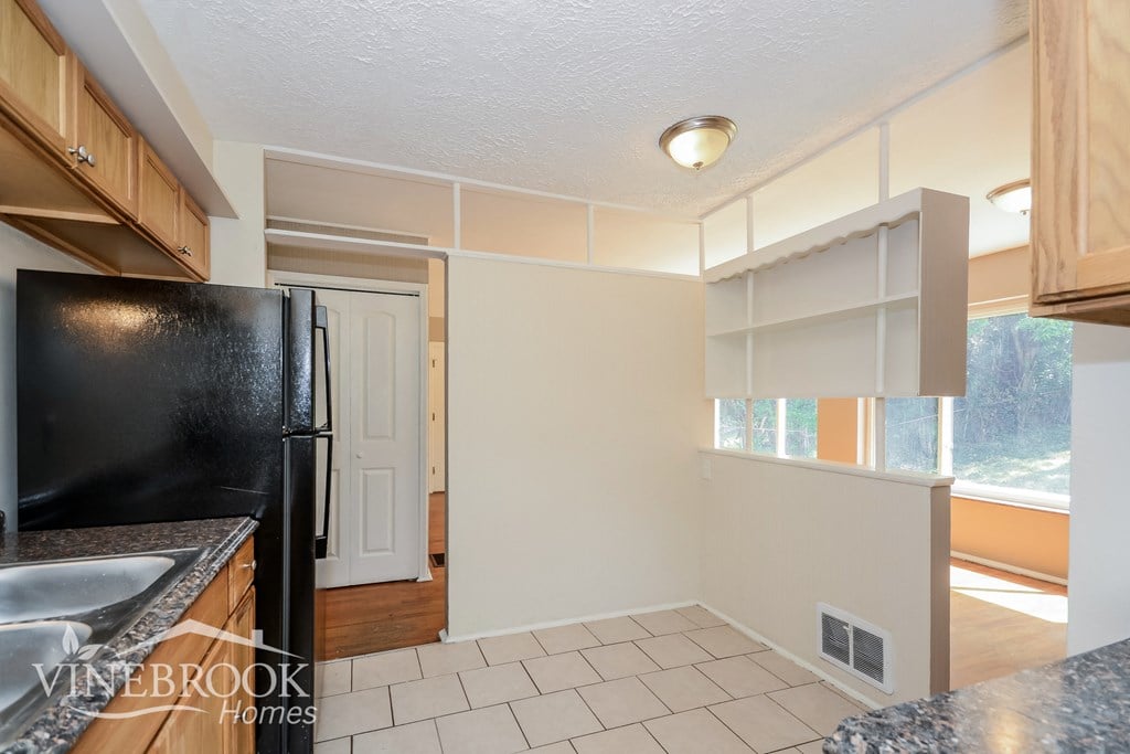a kitchen with a black refrigerator and a sink