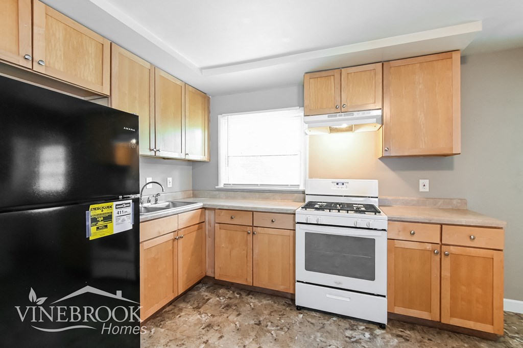 a kitchen with wooden cabinets and a white stove and refrigerator