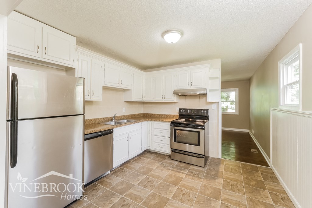 a kitchen with white cabinets and stainless steel appliances