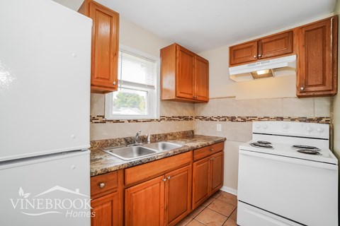 a kitchen with white appliances and wooden cabinets