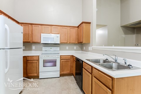 A kitchen with wooden cabinets and a white fridge.