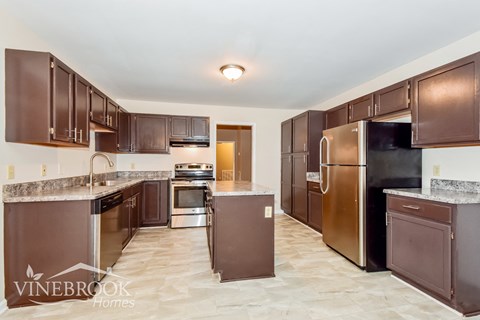 A kitchen with brown cabinets and appliances.