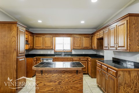 A kitchen with wooden cabinets and a black countertop.