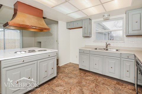 A kitchen with a white counter top and a sink.