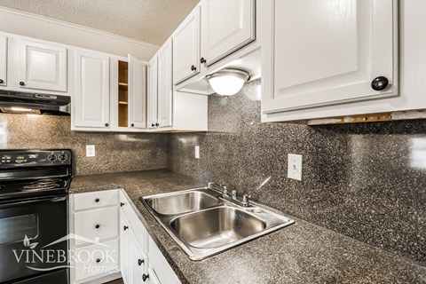 A kitchen with a sink and a stove.