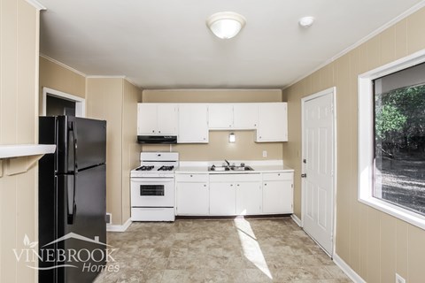 A kitchen with white cabinets and appliances is shown.