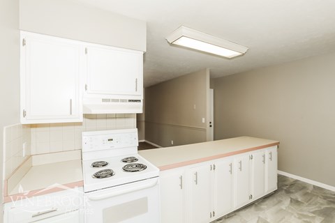 A white kitchen with a stove and cabinets.