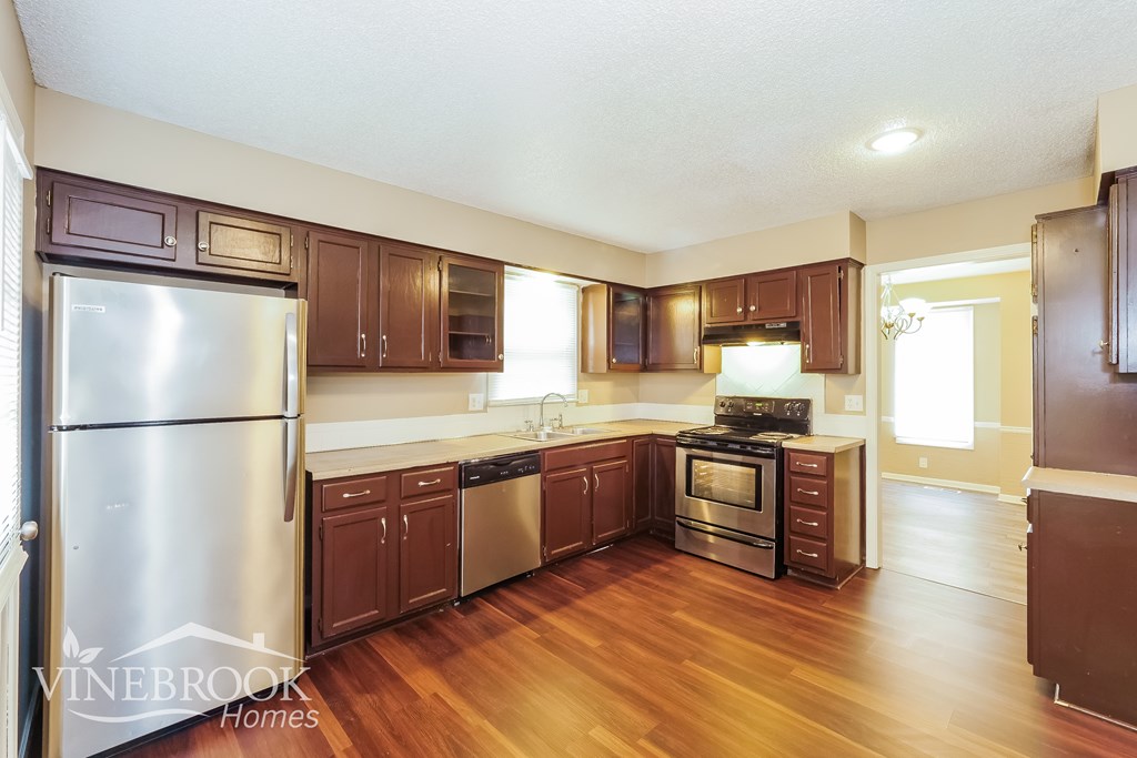 A kitchen with wooden floors and stainless steel appliances.