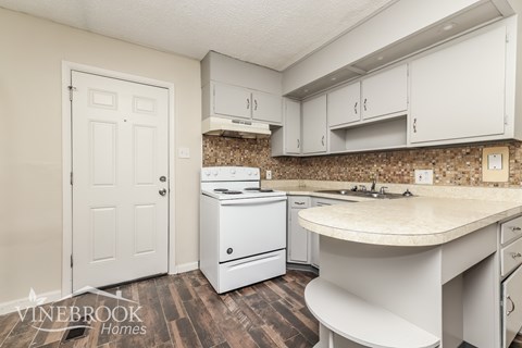 A kitchen with white appliances and cabinets.