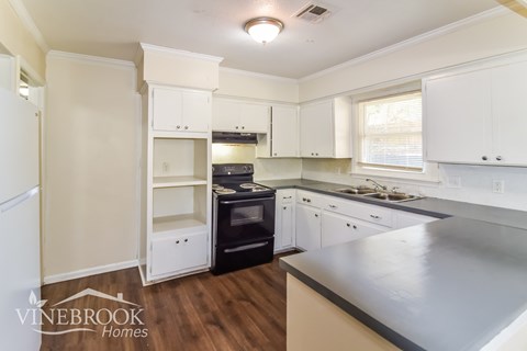 A kitchen with white cabinets and a stainless steel counter.