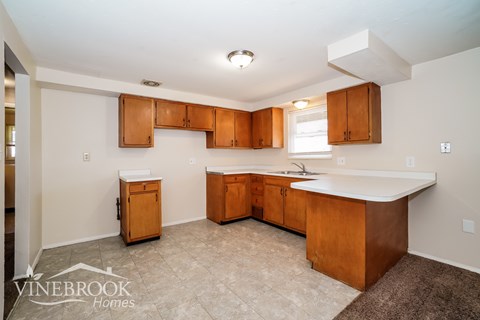 A kitchen with wooden cabinets and a white countertop.