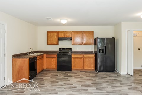 A kitchen with wooden cabinets and black appliances.
