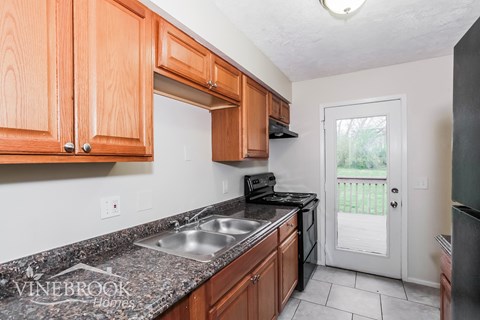 A kitchen with wooden cabinets and a granite countertop.