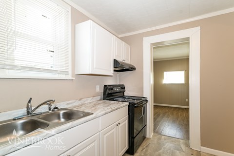 A kitchen with a sink, stove, and oven.