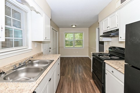 A kitchen with a black stove top oven and a window.