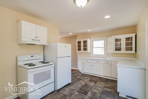 A kitchen with white appliances and cabinets.