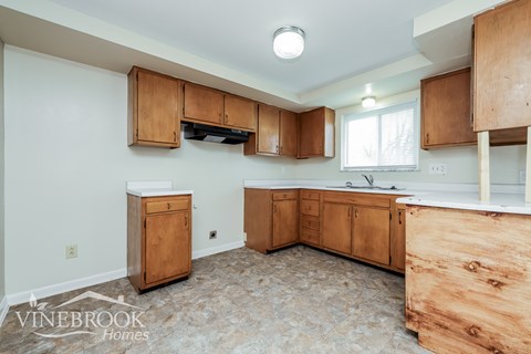 A kitchen with wooden cabinets and a countertop is shown.